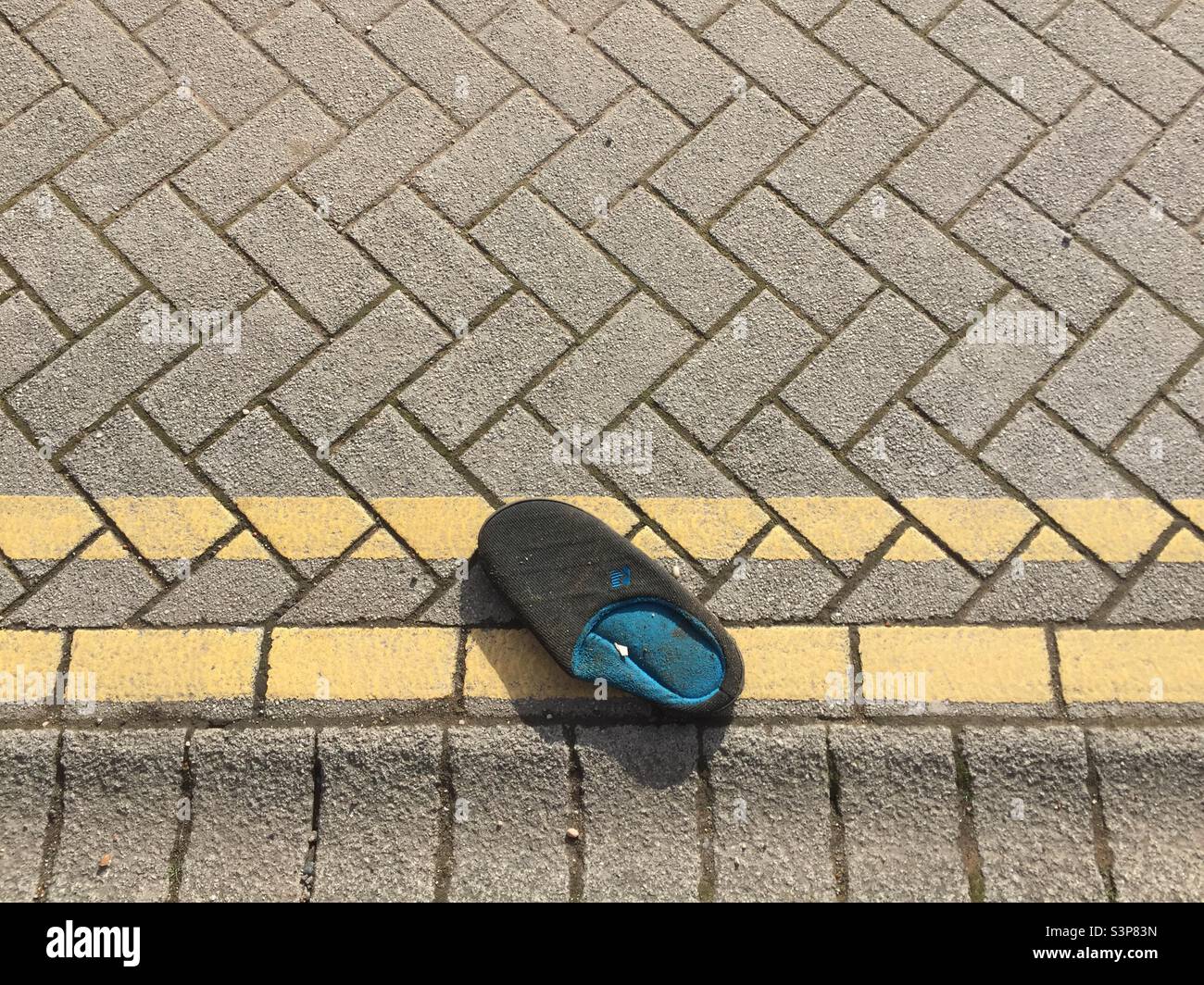 Discarded slipper on double yellow line Stock Photo