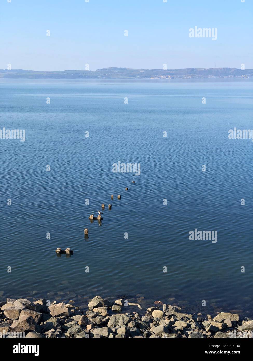 Small ruined stone pier at Newhaven on the Forth estuary, Edinburgh Scotland - Smartphone Captured Stock Image