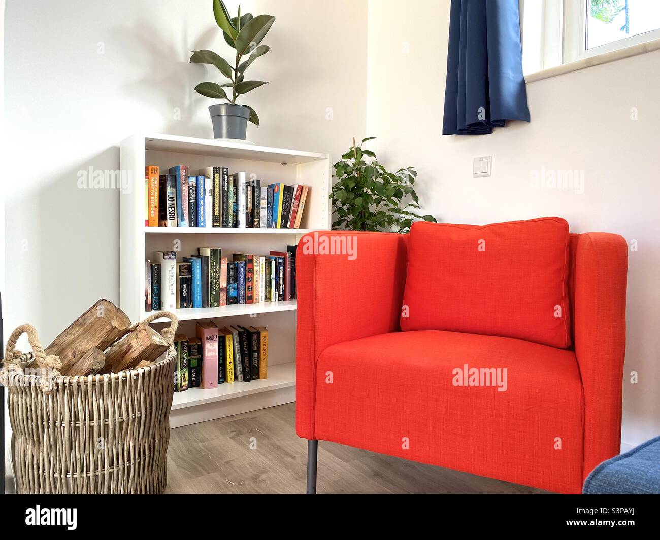 Modern home interior with red armchairs and books on small bookcase Stock Photo