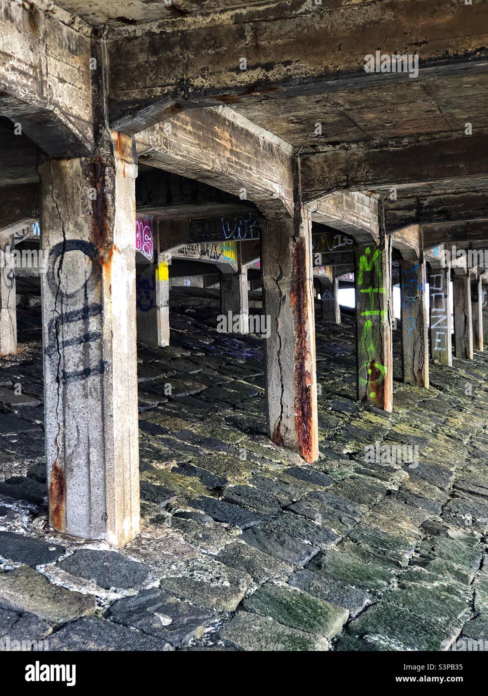 Underneath an abandoned stone pier at the coast - Smartphone Captured Stock Image