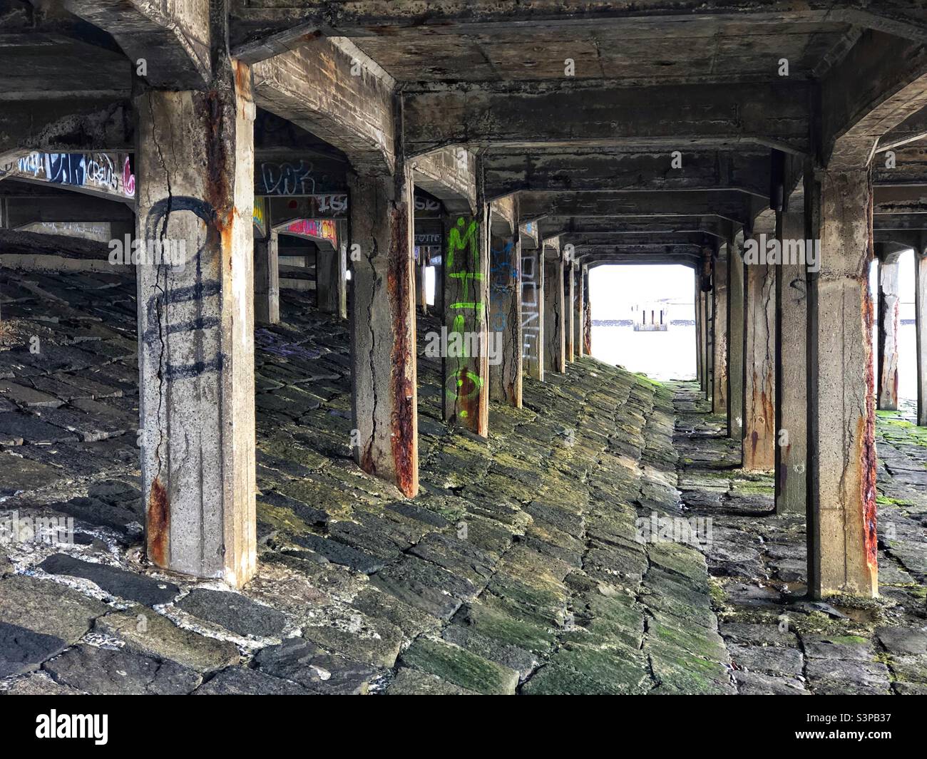 Underneath an abandoned stone pier at the coast - Smartphone Captured Stock Image