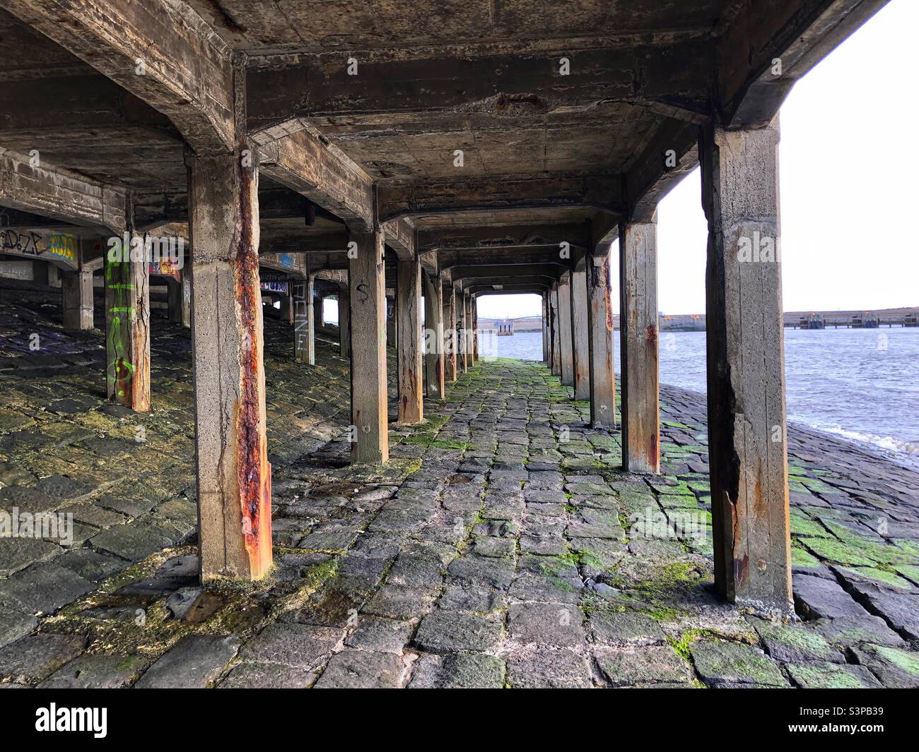 Underneath an abandoned stone pier at the coast - Smartphone Captured Stock Image