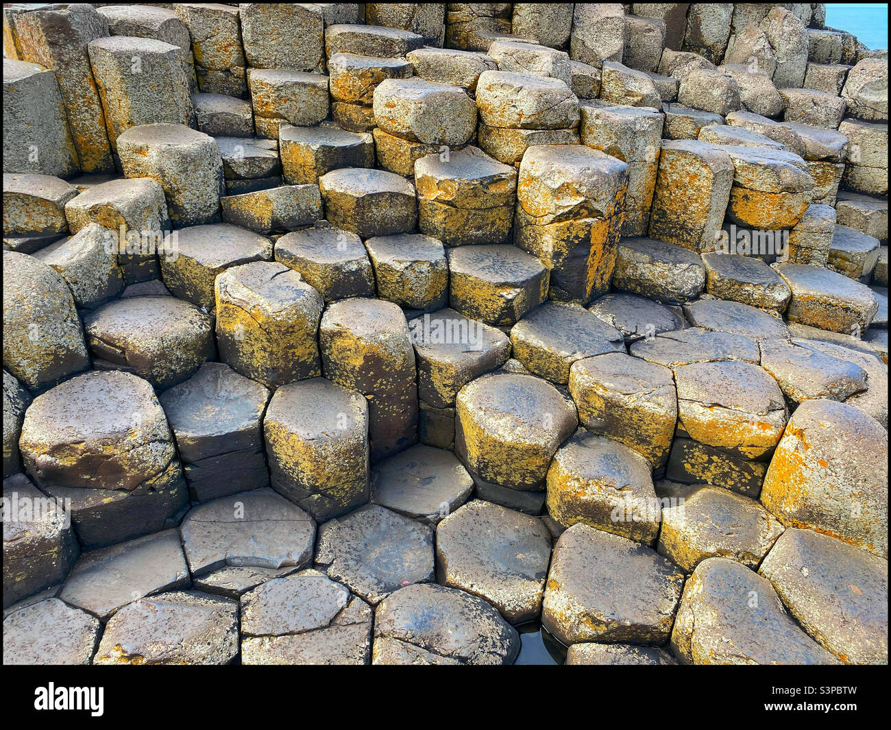 The iconic shapes of the hexagonal volcanic rock columns that form the topography at Giant’s Causeway in Northern Ireland. This famous location is visited by approx. 1 million people annually. ©️ CH. Stock Photo