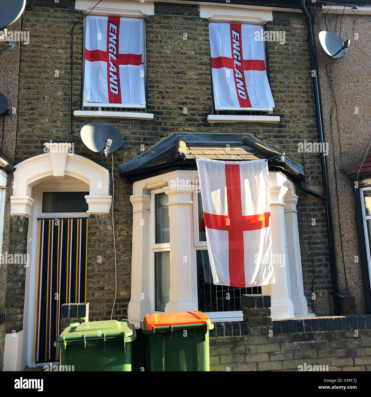 Flags of England hanging on windows outside the house in East London