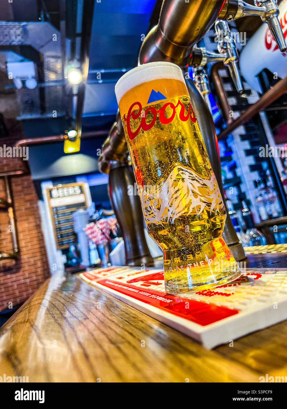 Pint of refreshing Coors lager in trendy bar in Leeds - Smartphone Captured Stock Image