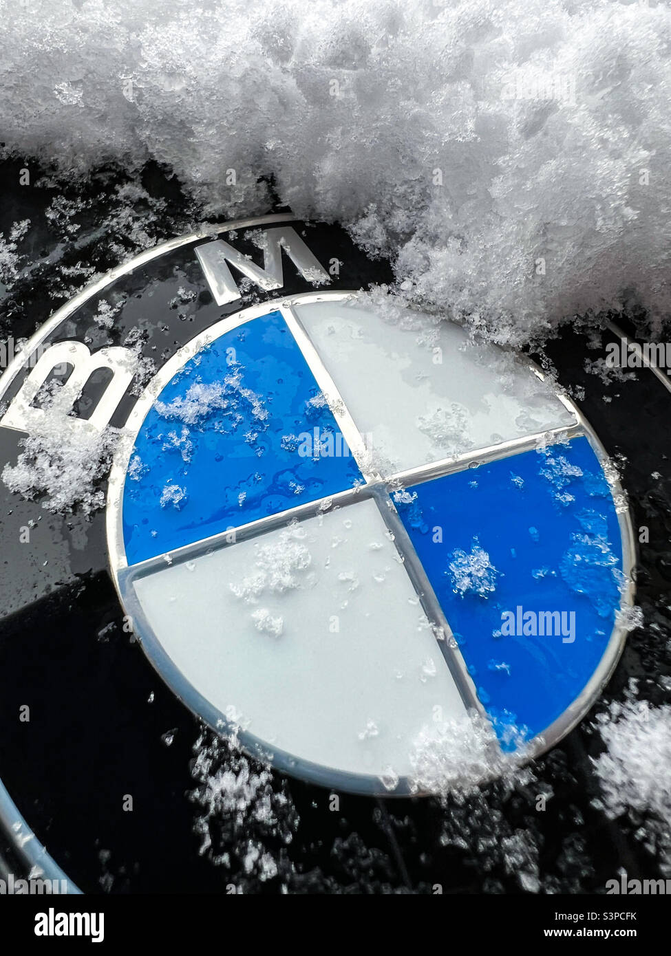 BMW logo badge covered in snow Stock Photo