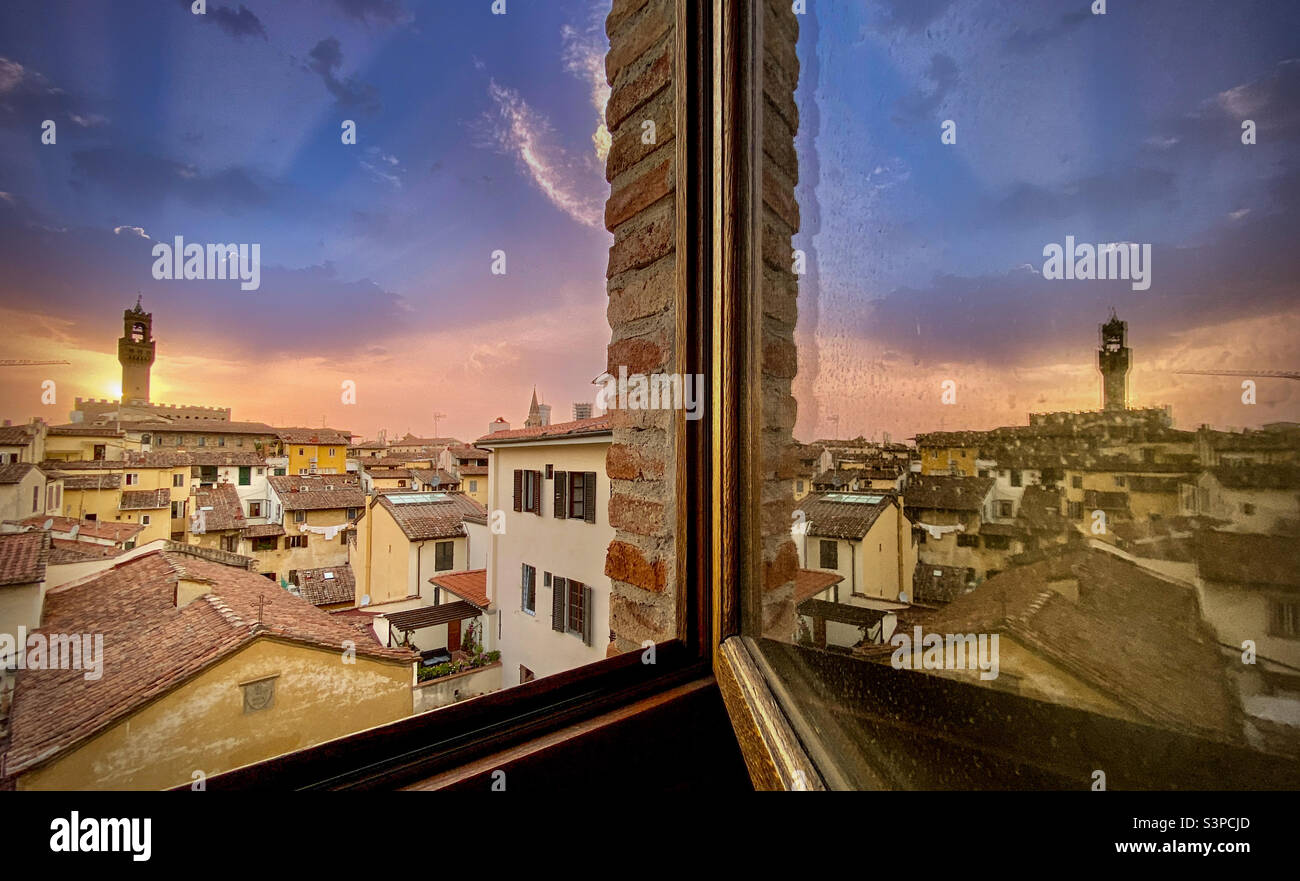 The skyline of Florence, Italy at sunset with the famed Palazzo Vecchio reflected from a hotel room - Smartphone Captured Stock Image