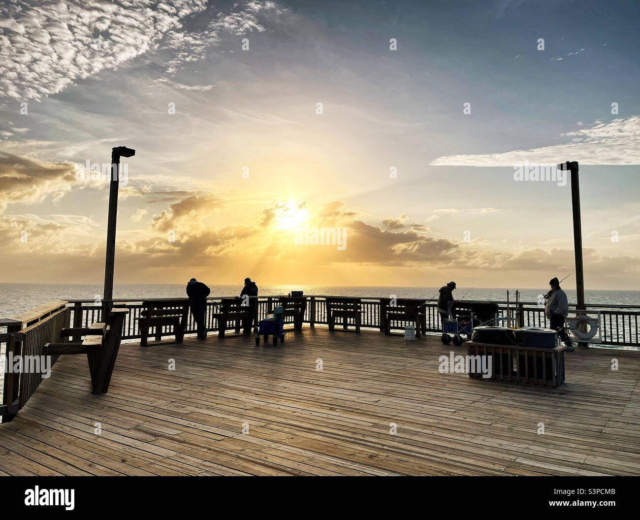 People fishing during sunrise on Springmaid Pier in Myrtle Beach South Carolina USA. Stock Photo