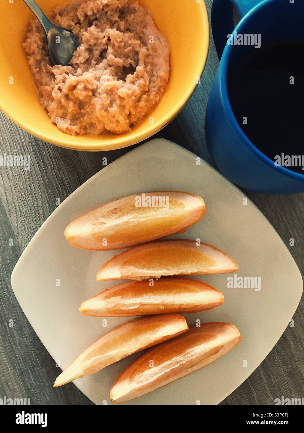 Healthy breakfast: oatmeal, orange slices and black coffee - Smartphone Captured Stock Image