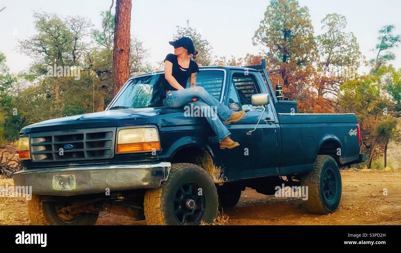 Woman sitting on hood of truck Stock Photo Alamy