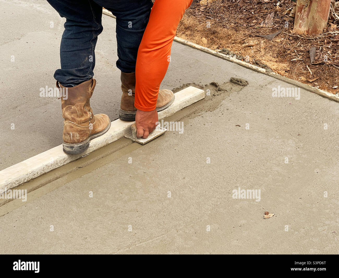 Construction worker creating contraction joints in wet cement Stock Photo Alamy