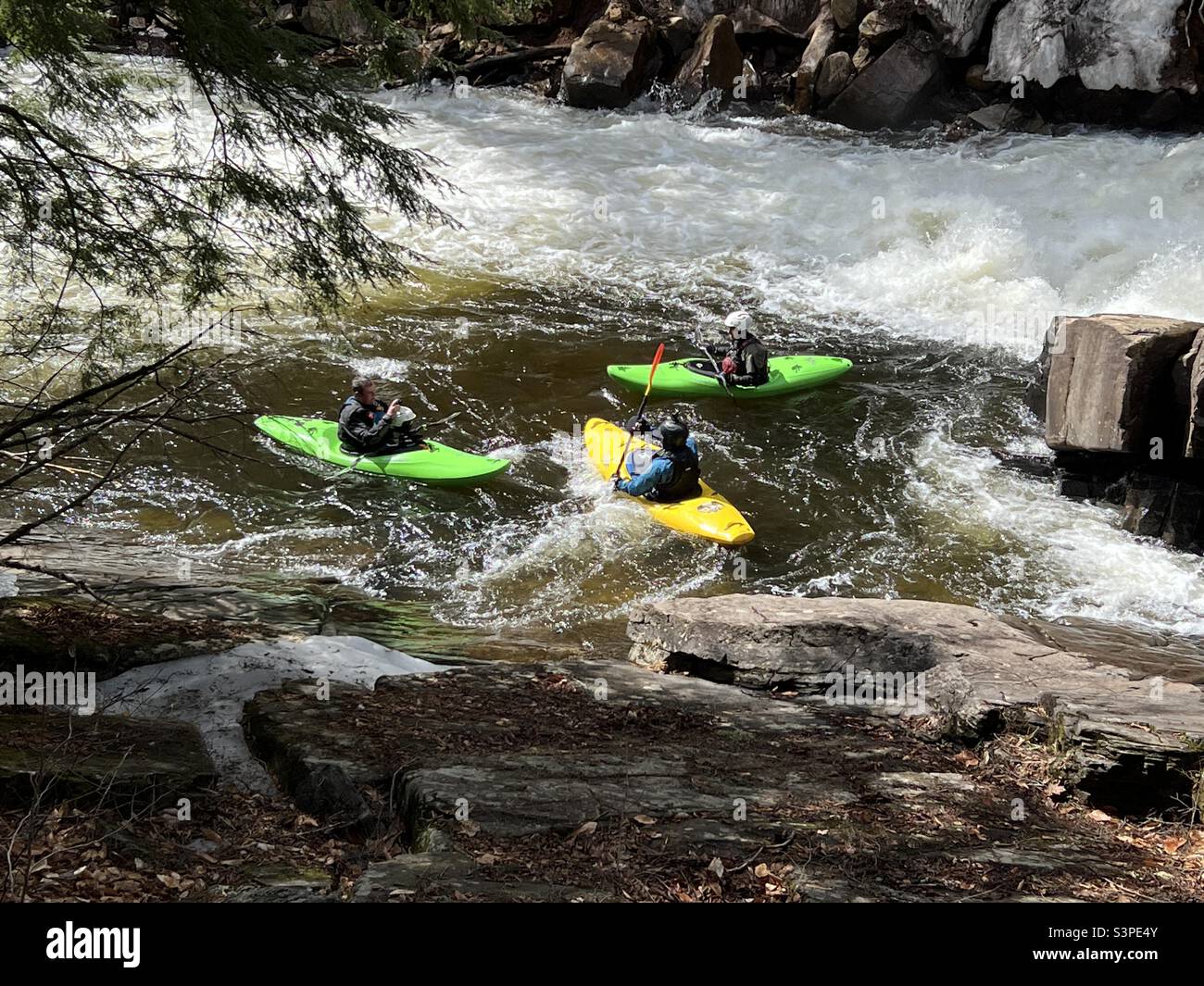 Three whitewater kayaks at Austin Falls on the Sacandaga River in early spring Stock Photo