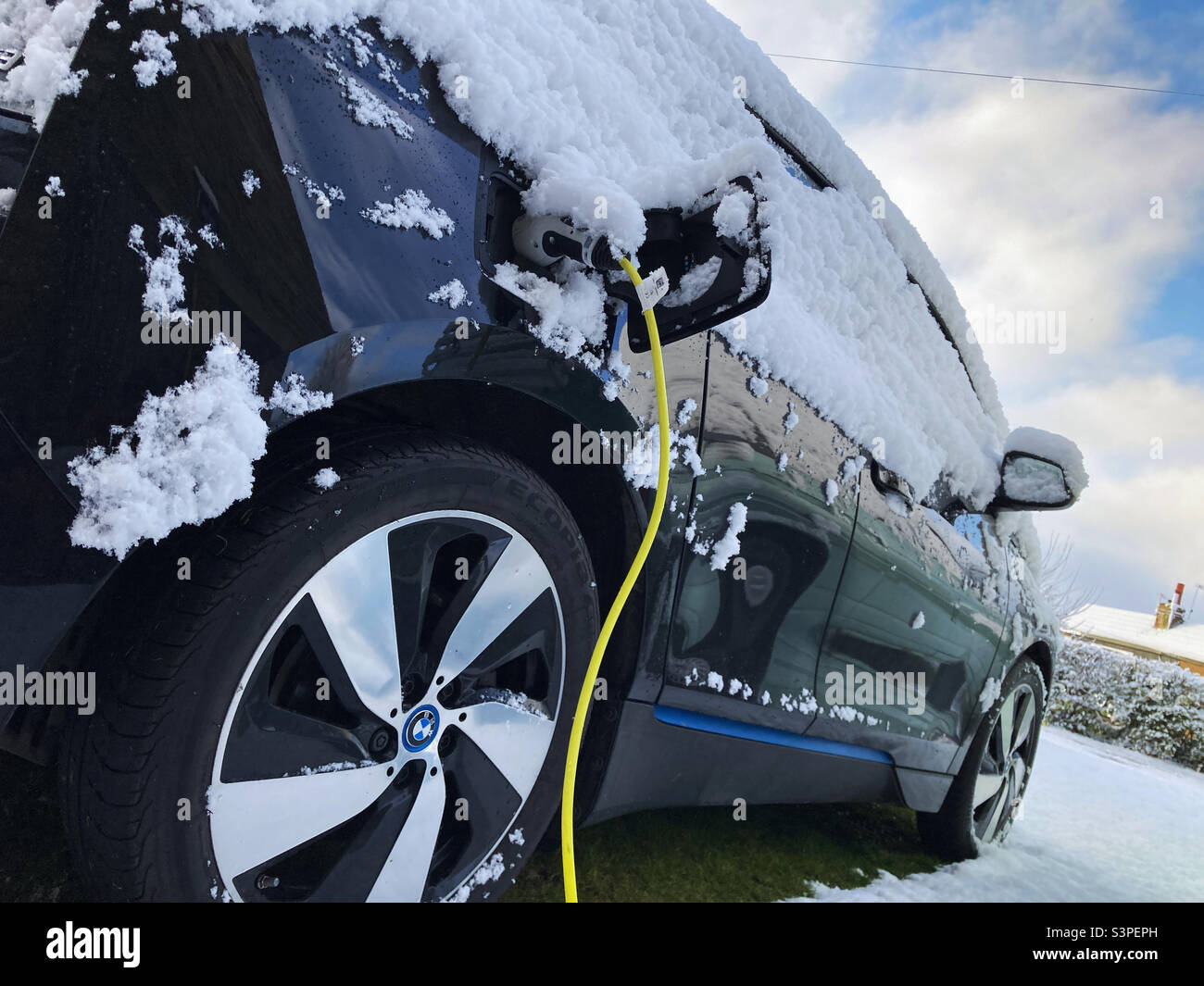BMW i3 electric car charging on winter day in the snow Stock Photo