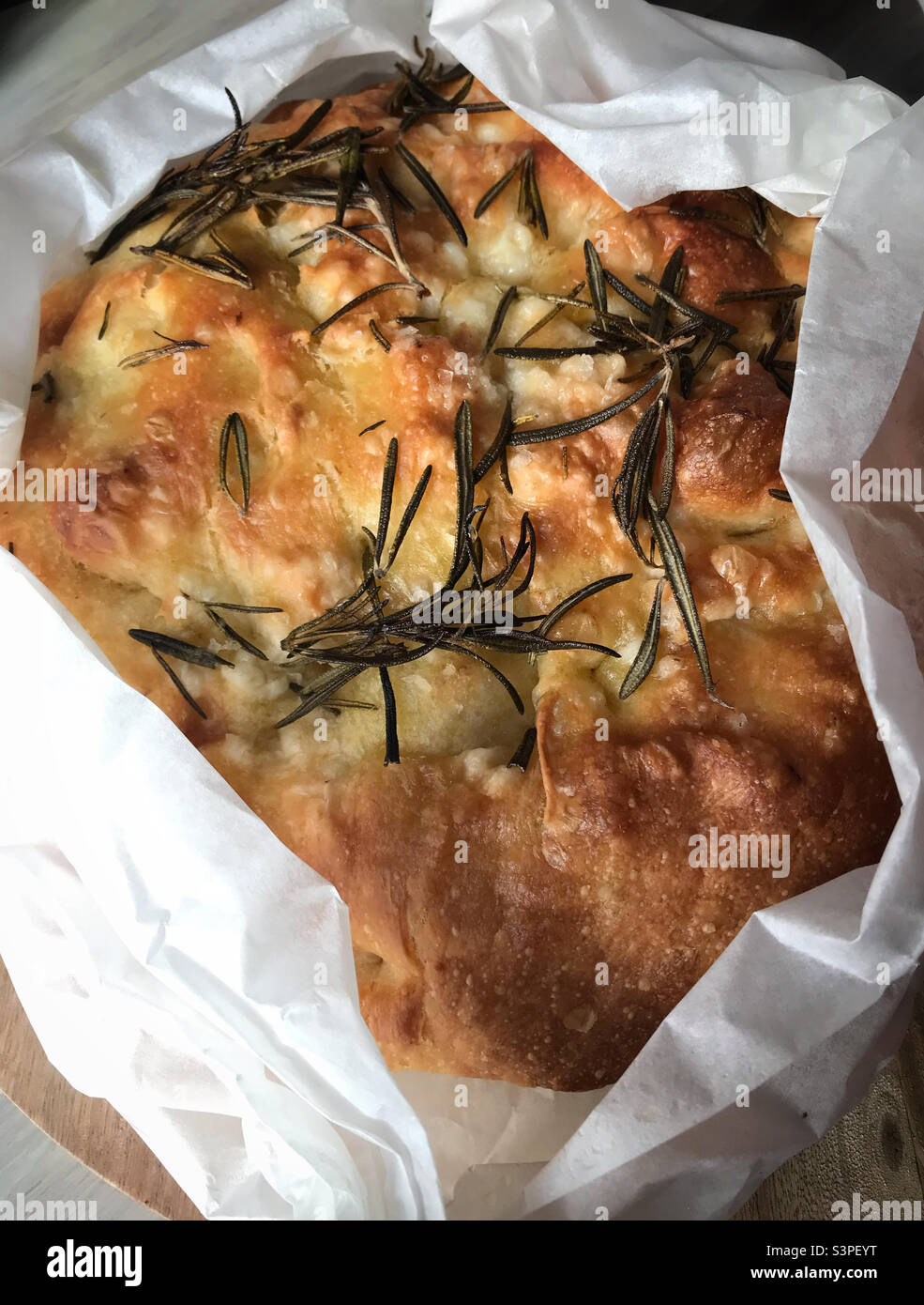 A focaccia loaf being unwrapped - Smartphone Captured Stock Image
