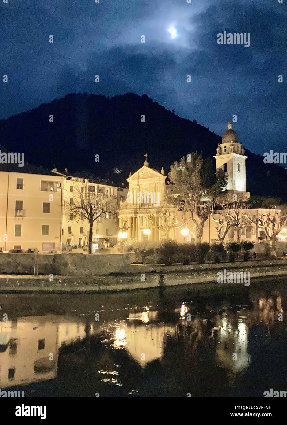 A cloudy full moon over the Church of Saint Anthony Abbott, Chiesa Parrocchiale di Sant'Antonio Abate in Dolceacqua, Italy. - Smartphone Captured Stock Image