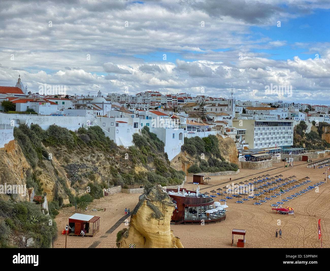 View at Albufeira town with white buildings, churches and part of the sandy beach in Algarve, Portugal. - Smartphone Captured Stock Image