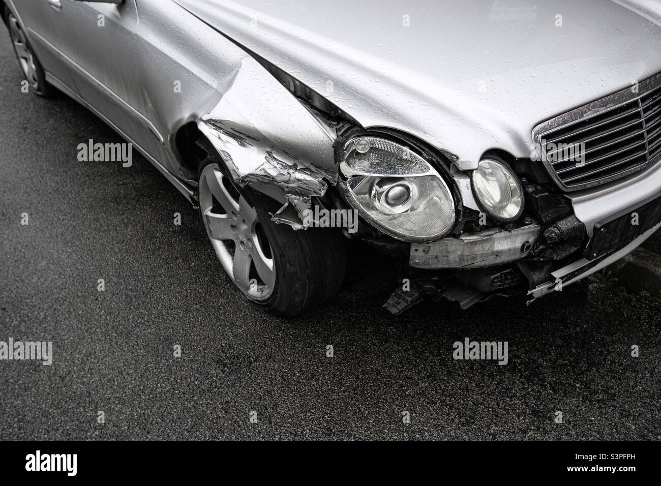A motor car that has been involved in a road traffic accident with damage to the front wing headlights and wheel with copy space Stock Photo