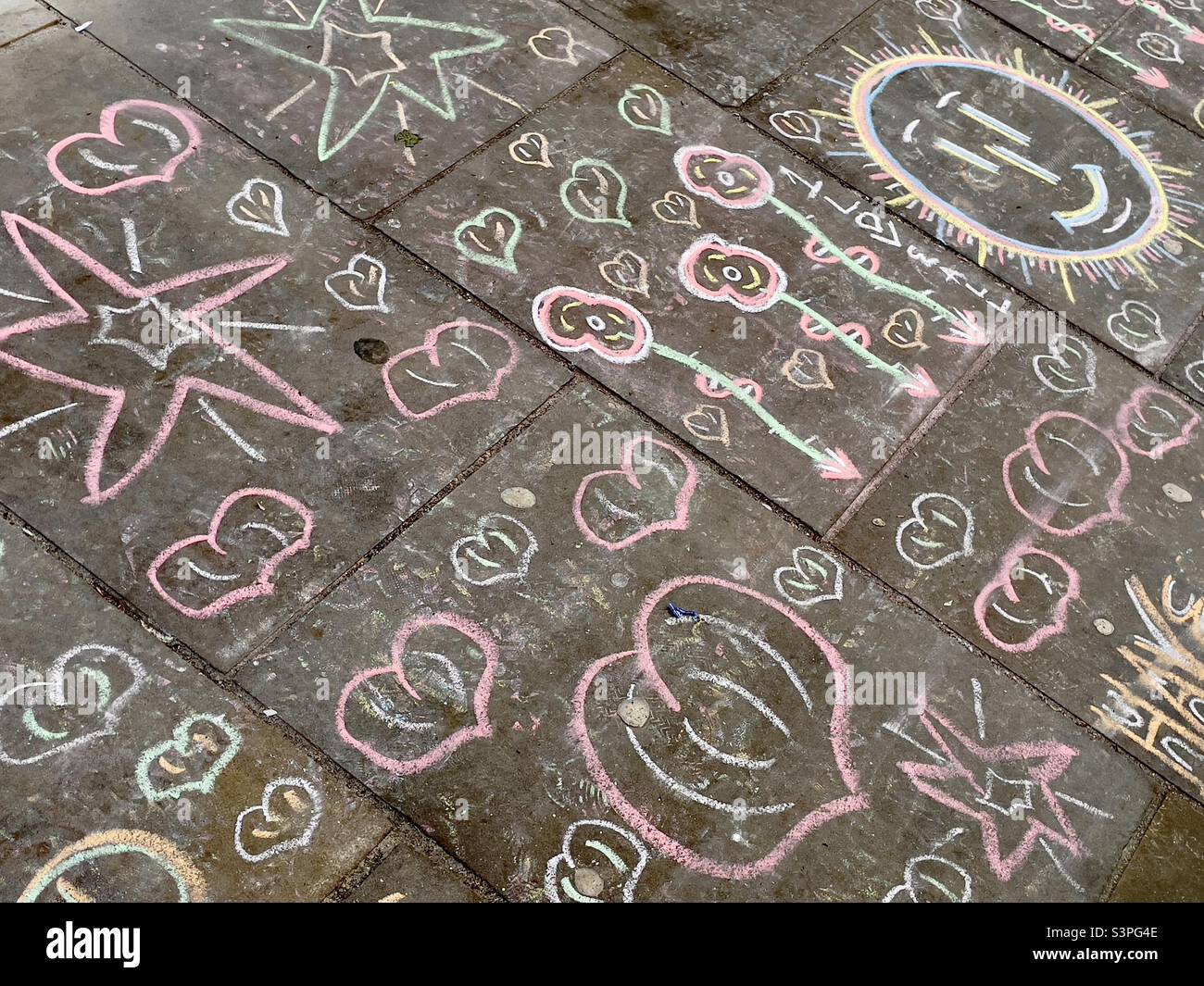 The graffiti of a begging pavement artist on the flag stones of Church Street in Worcester UK Stock Photo