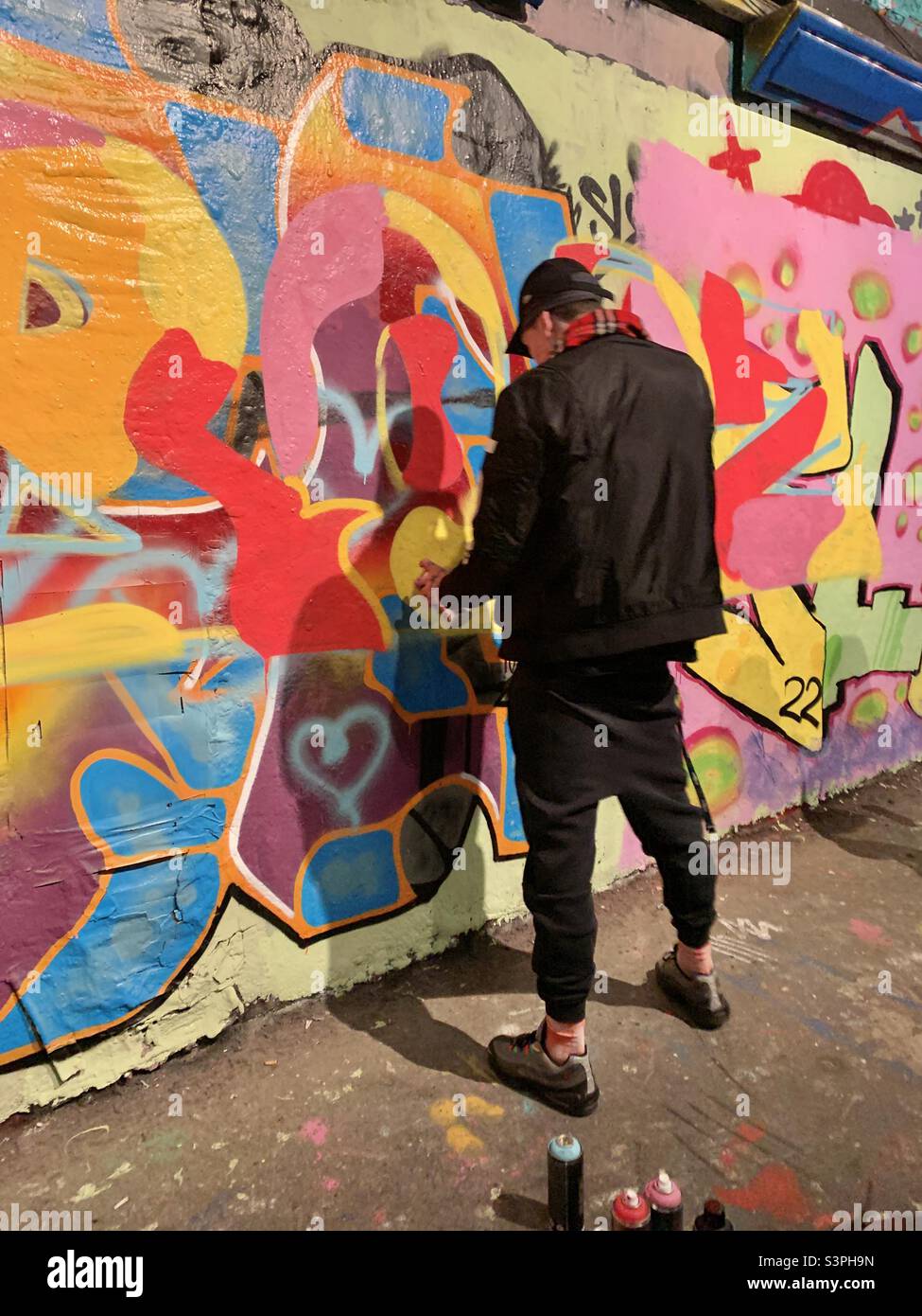 Graffiti artist spray painting a wall Stock Photo Alamy