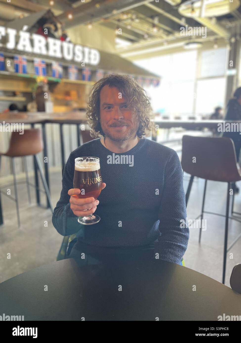 Handsome man enjoying a beer in food hall in Reykjavik, Iceland - Smartphone Captured Stock Image
