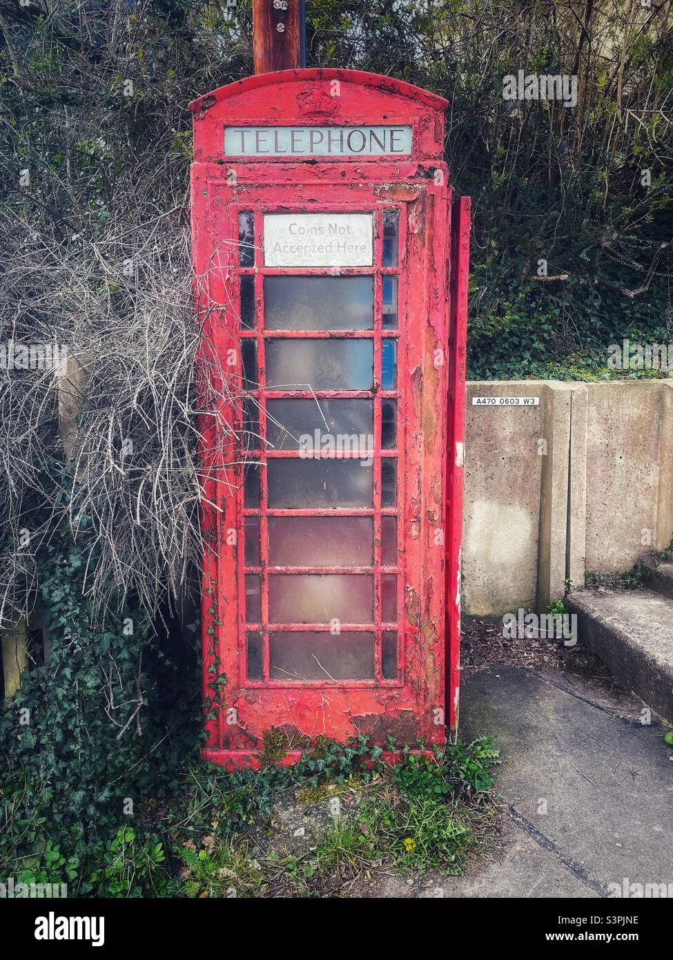 Old red UK phone box with peeling red paint on the A470 road through Wales, 2022. Stock Photo