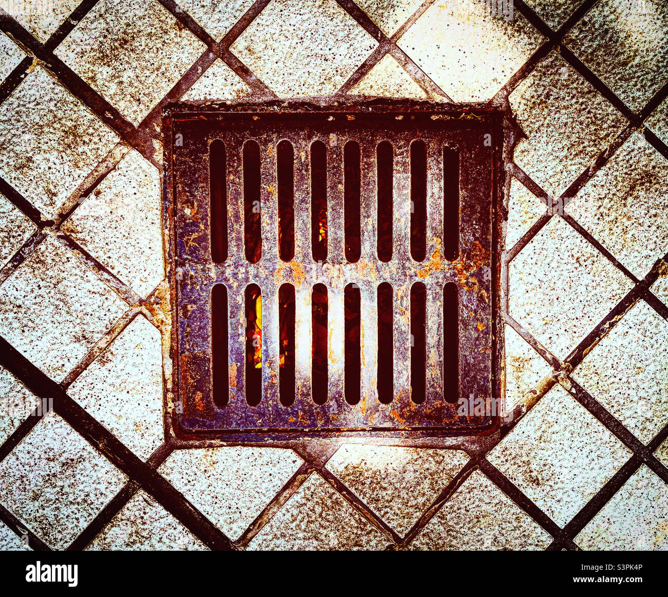 top view of rusted metal grid of a drain on the pavment in the street Stock Photo