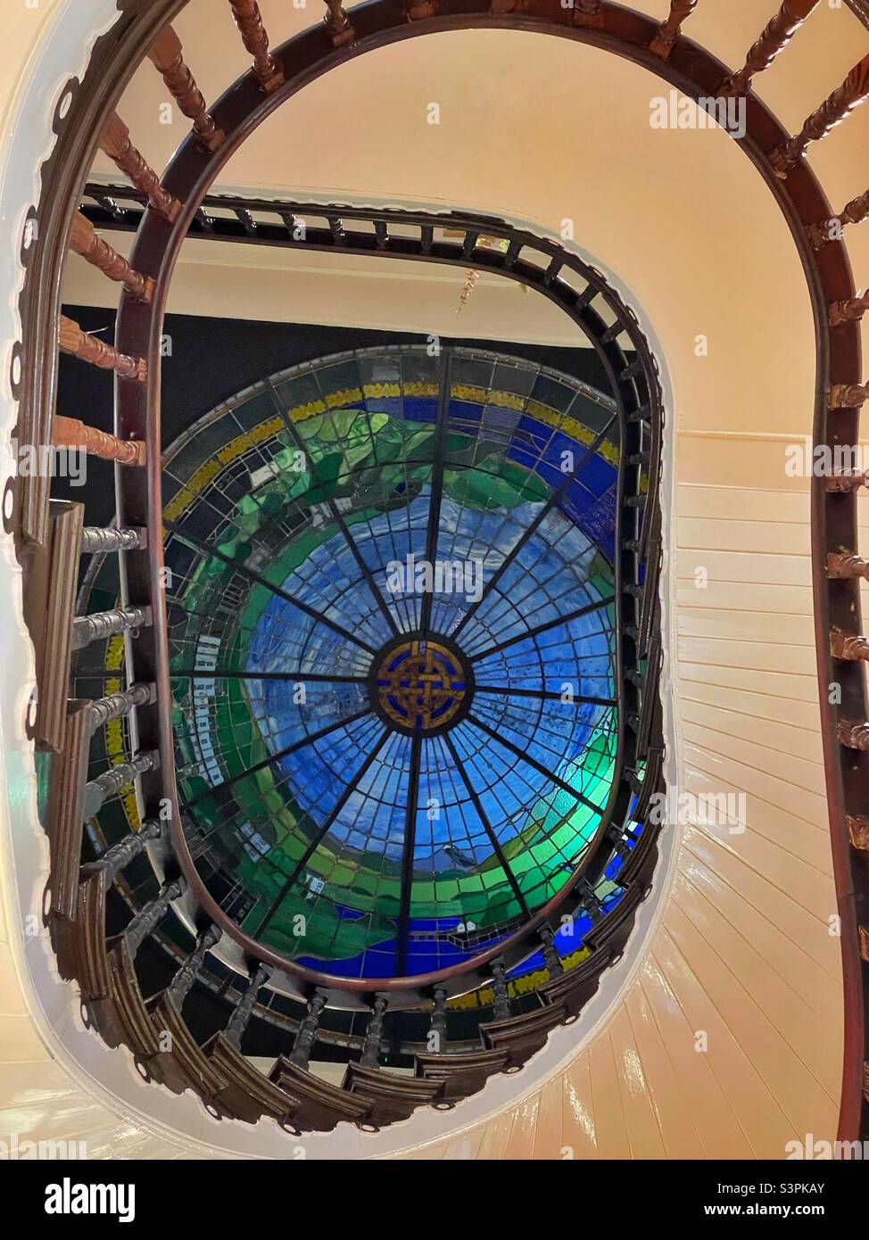 Spiral staircase leading up to a stained glass ceiling in the Portmeirion shop, Porthmadog, North Wales. Stock Photo