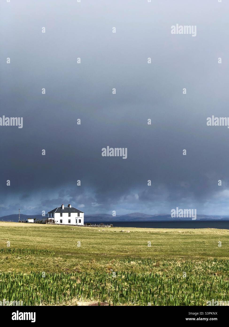 White House under a cloudy brooding sky, Isle of Iona, Scotland - Smartphone Captured Stock Image