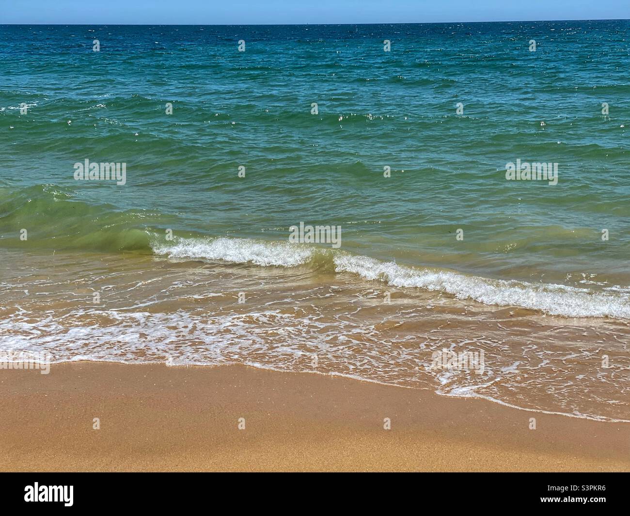 Sea wave on a sunny sandy beach in Portugal. - Smartphone Captured Stock Image