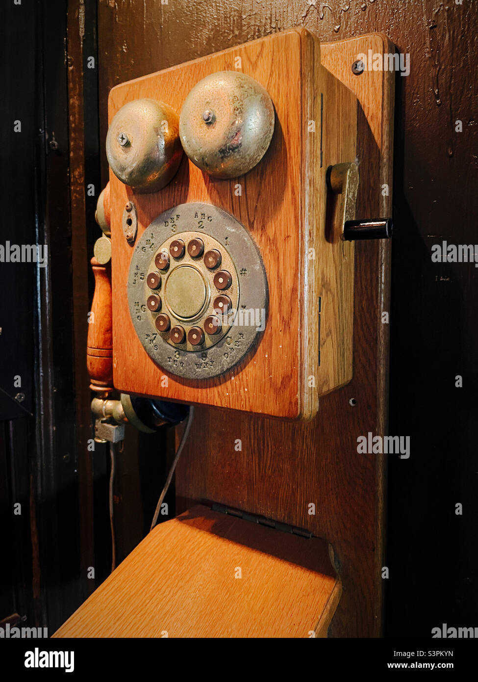 Vintage wall mounted wooden telephone with exterior bells and push button dial, 2022 Stock Photo