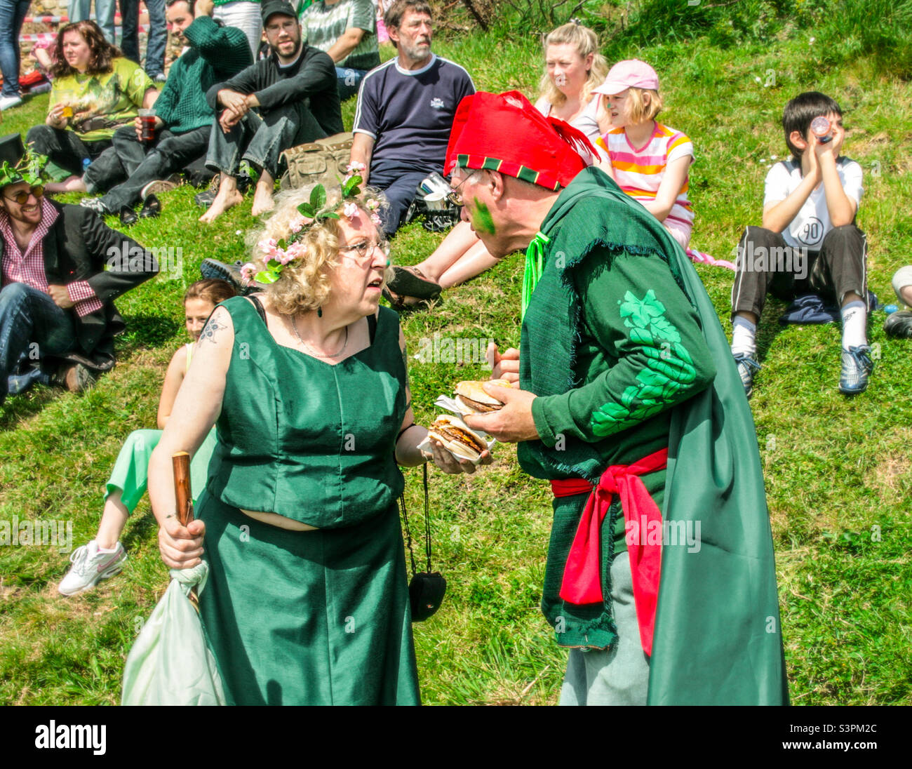 A couple in costume grab a quick bite to eat at Traditional Hastings Jack in the Green festivities. UK, May 2008 - Smartphone Captured Stock Image
