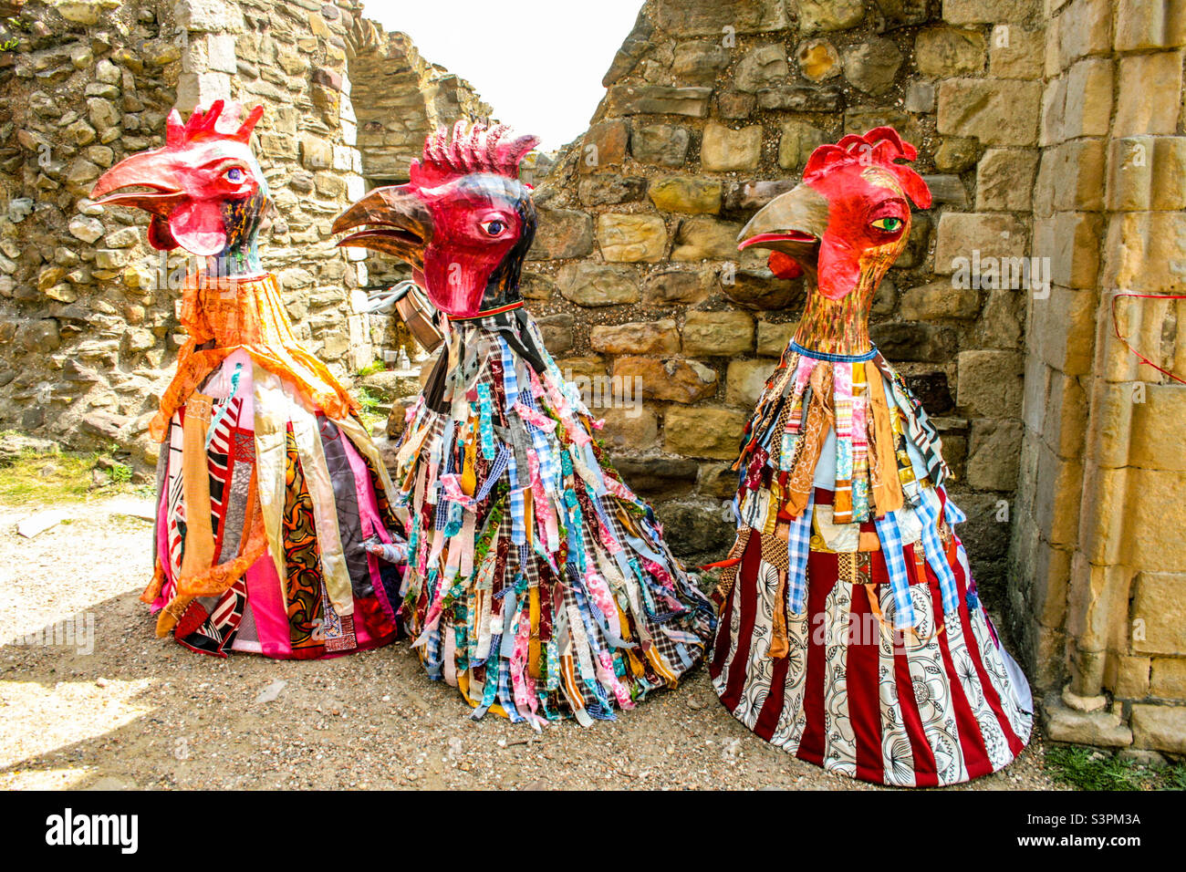 3 decorated cockerel effigies, standing within the castle walls at Traditional Hastings Jack in the Green festivities. UK, May 2008 Stock Photo