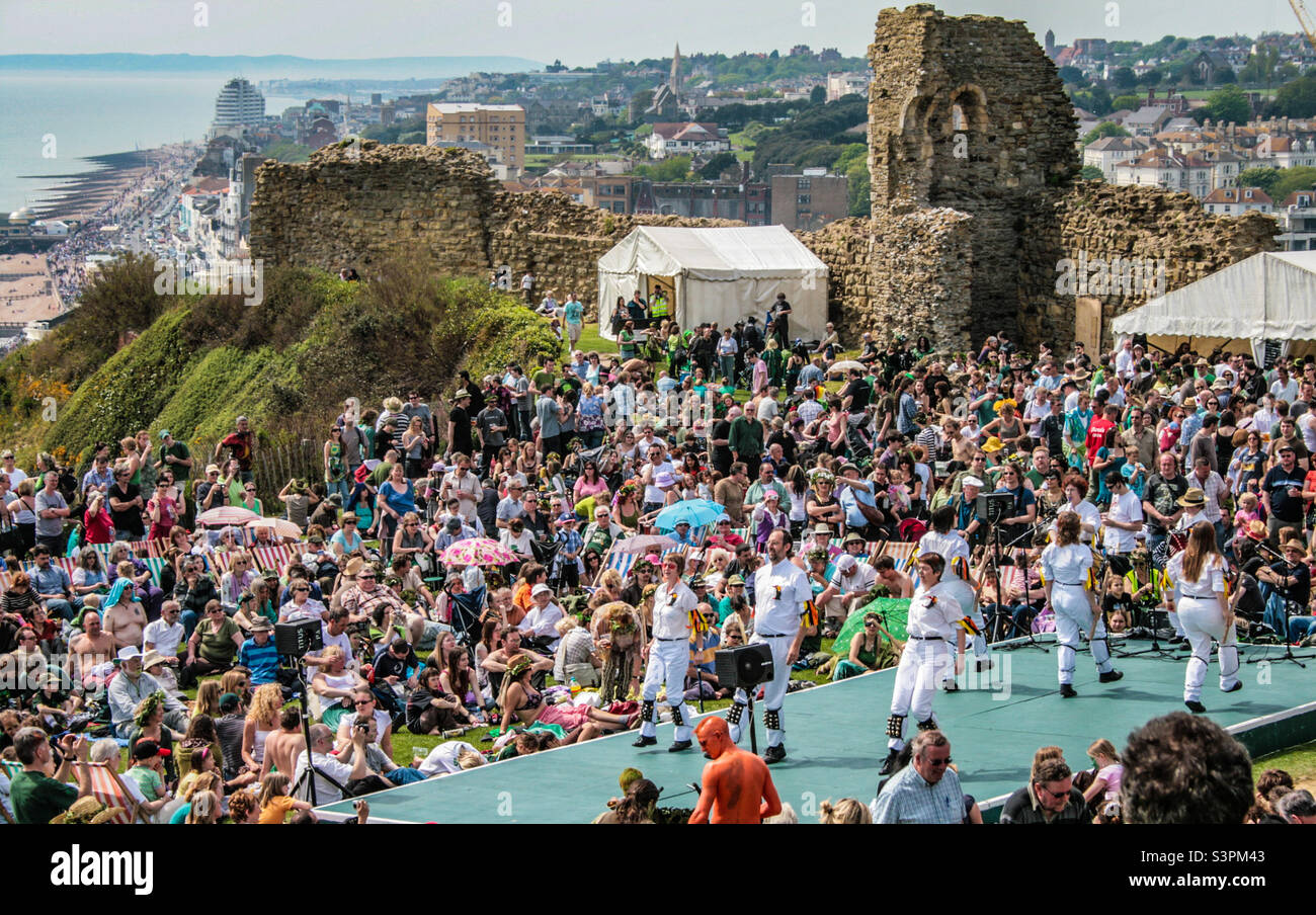 Morris Dancers perform in front of a crowd high on the hill against a backdrop of the Sussex coastline at Traditional Hastings Jack in the Green festivities. UK, May 2008 - Smartphone Captured Stock Image