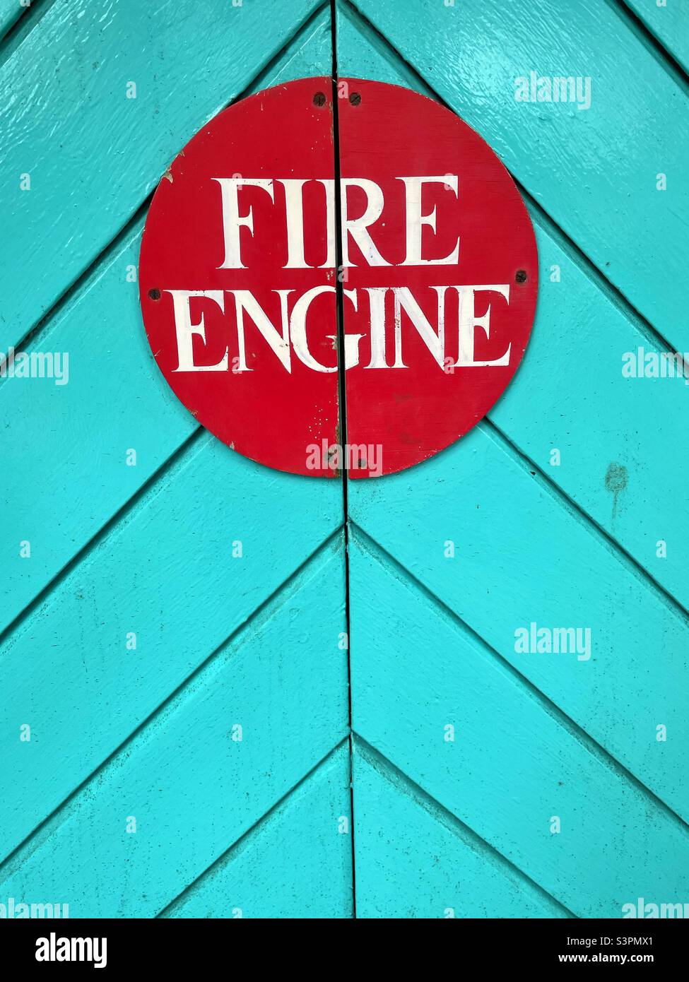 Fire Engine sign On a painted turquoise wooden door at Portmeirion, Gwynedd, North Wales. Stock Photo