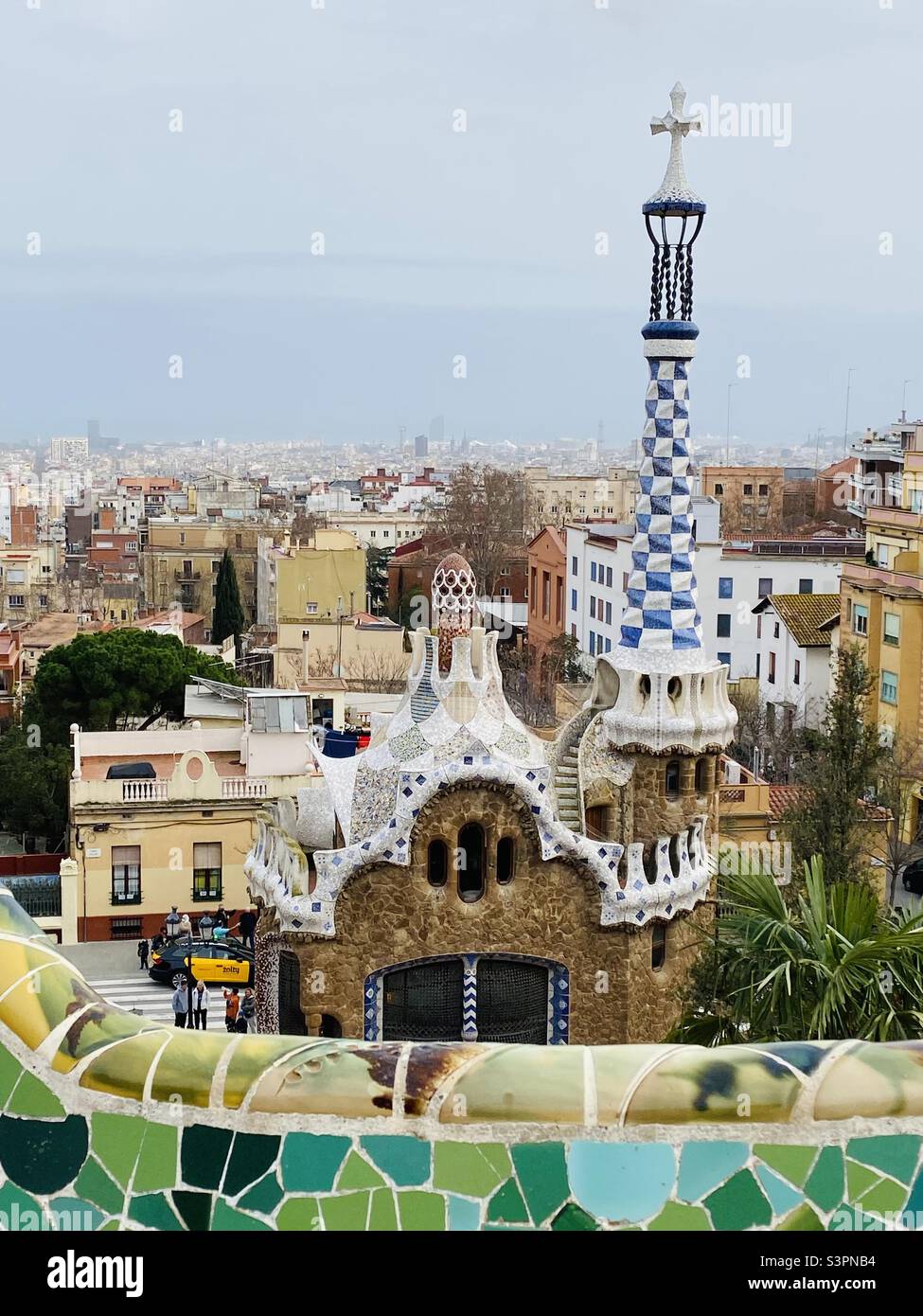 View of the Mushroom House and Barcelona from the plaza at Parc Güell, next to the serpentine bench. March 2022. - Smartphone Captured Stock Image