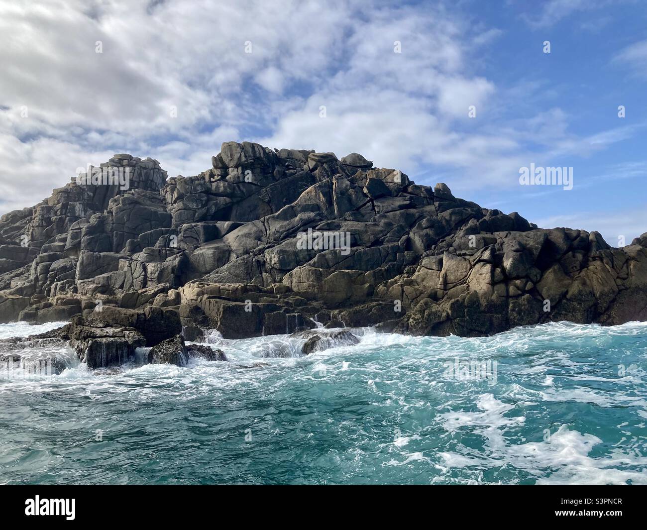 A wild sea washing against a rocky island, Isles of Scilly Stock Photo