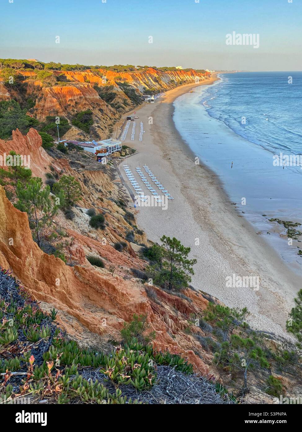 Golden hour colors before sunset on a ocean beach with sandstone rock formations in Algarve, Portugal. - Smartphone Captured Stock Image