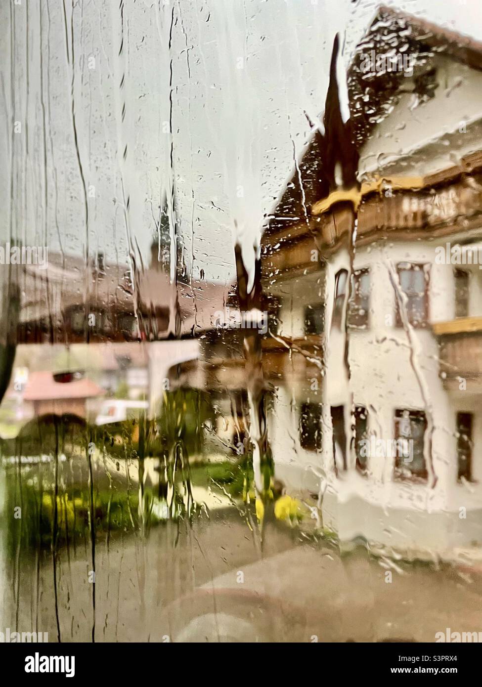 Black Forest village scene through rainy window - Smartphone Captured Stock Image