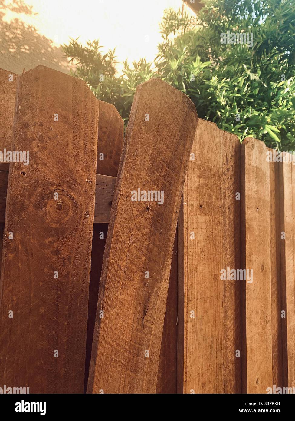 Cedar fence in the yard - broken wooden fence - broken board Stock Photo