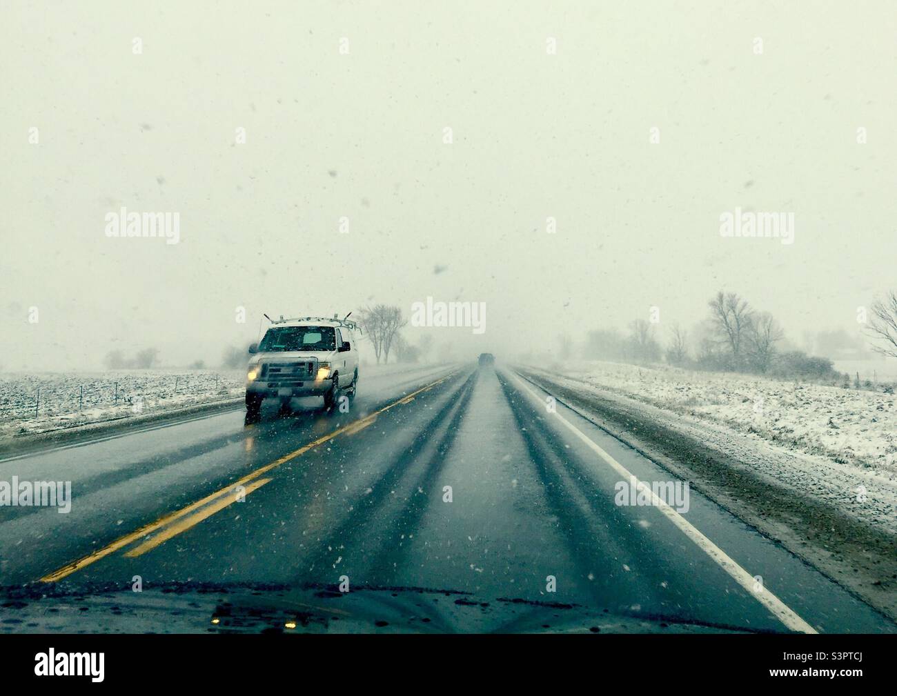 Driving in fog and snow on a twoway road, Ontario, Canada Stock Photo