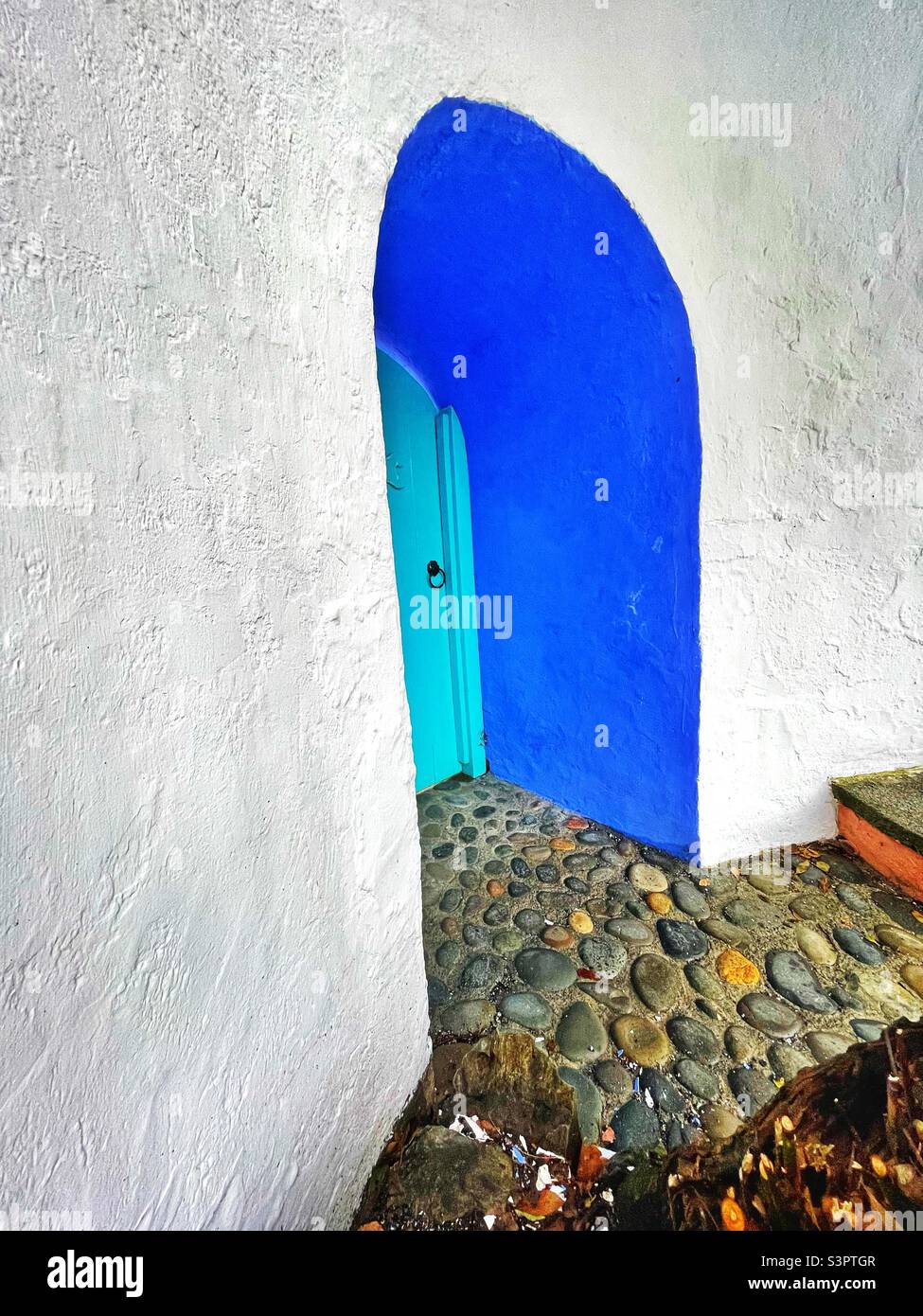 Hidden doorway set into a whitewashed wall at Portmeirion, Gwynedd, North Wales. Stock Photo