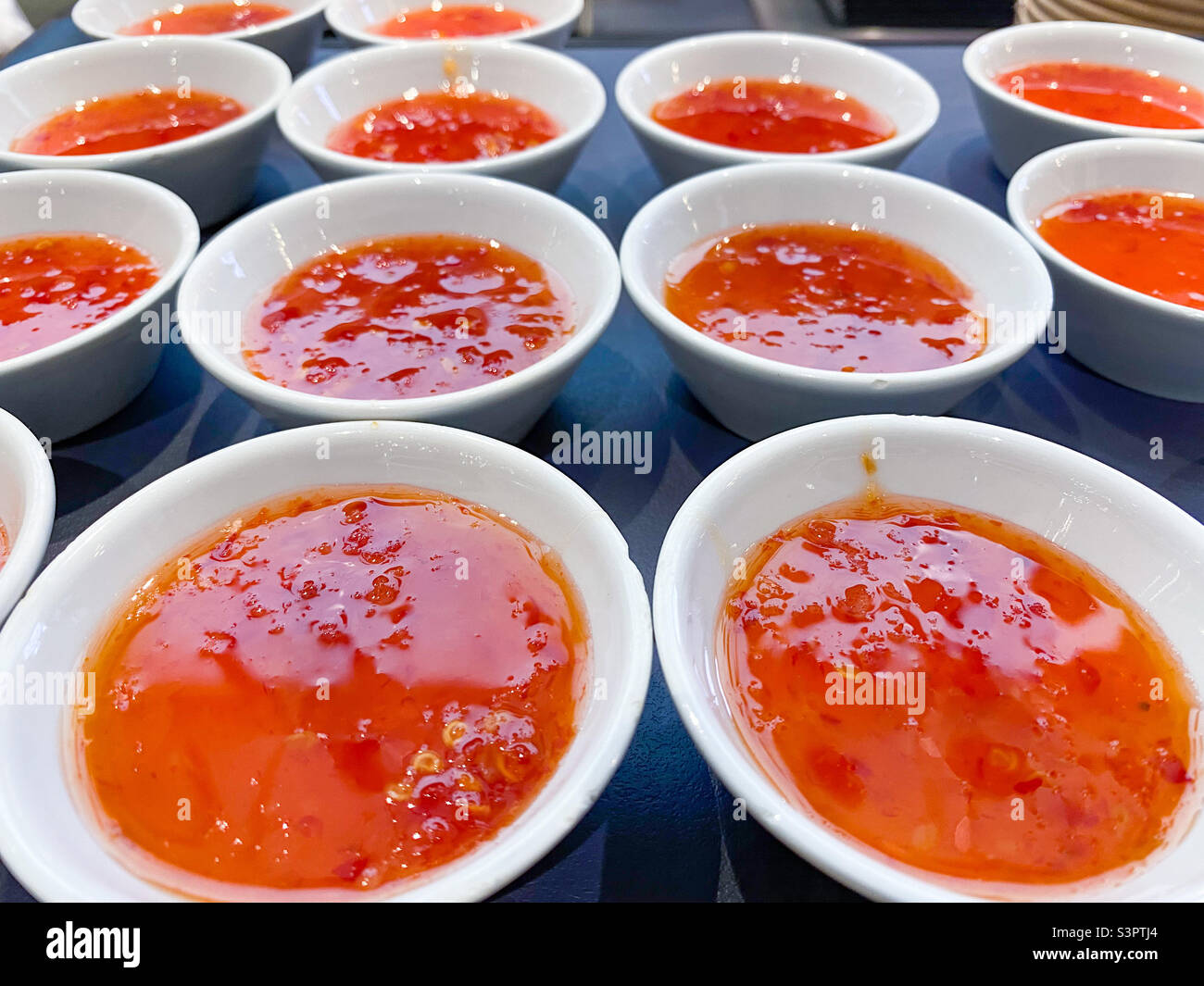 Small bowls full of sweet chilli sauce. - Smartphone Captured Stock Image
