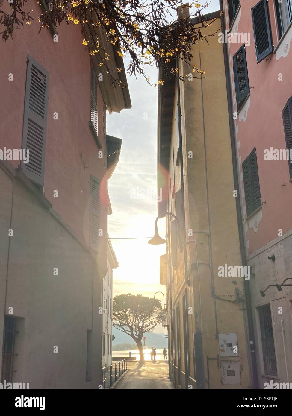 A romantic alley in Iseo leading to the Lago d‘Iseo with soft sunlight of the spring sun, Iseo, Lombardy, Italy Stock Photo