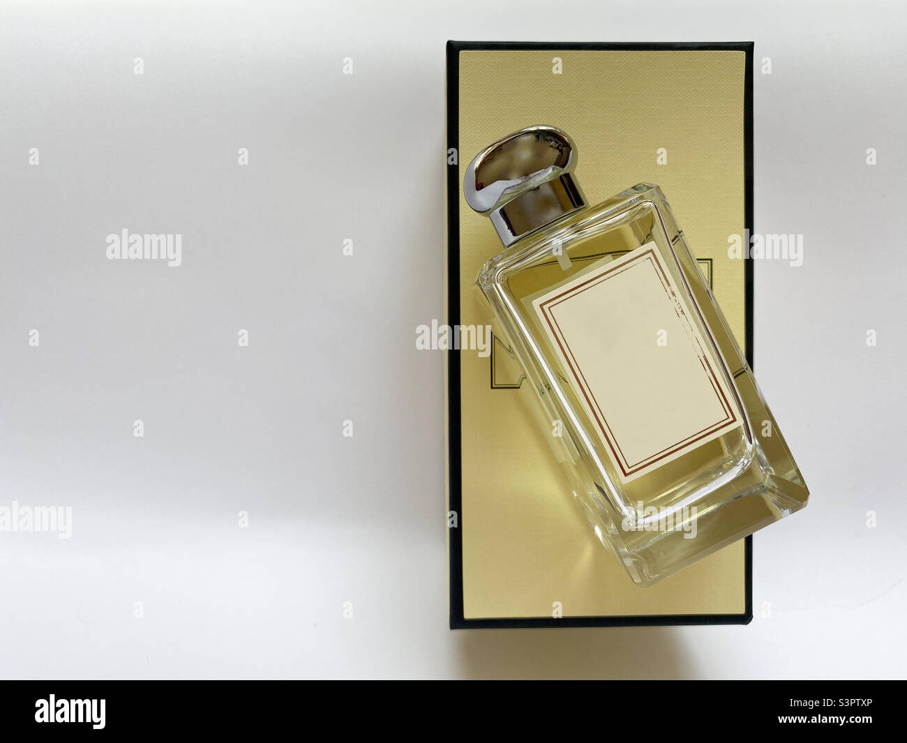 A bottle of perfume from a yellow box on a white isolated background - Smartphone Captured Stock Image