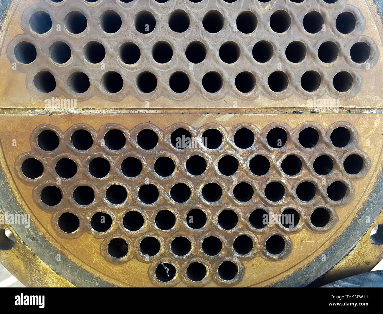 Shell-and-tube (shell-and-tube) heat exchanger for heat exchange between two streams close-up.  Dirty pipes in the opened heat exchanger Stock Photo