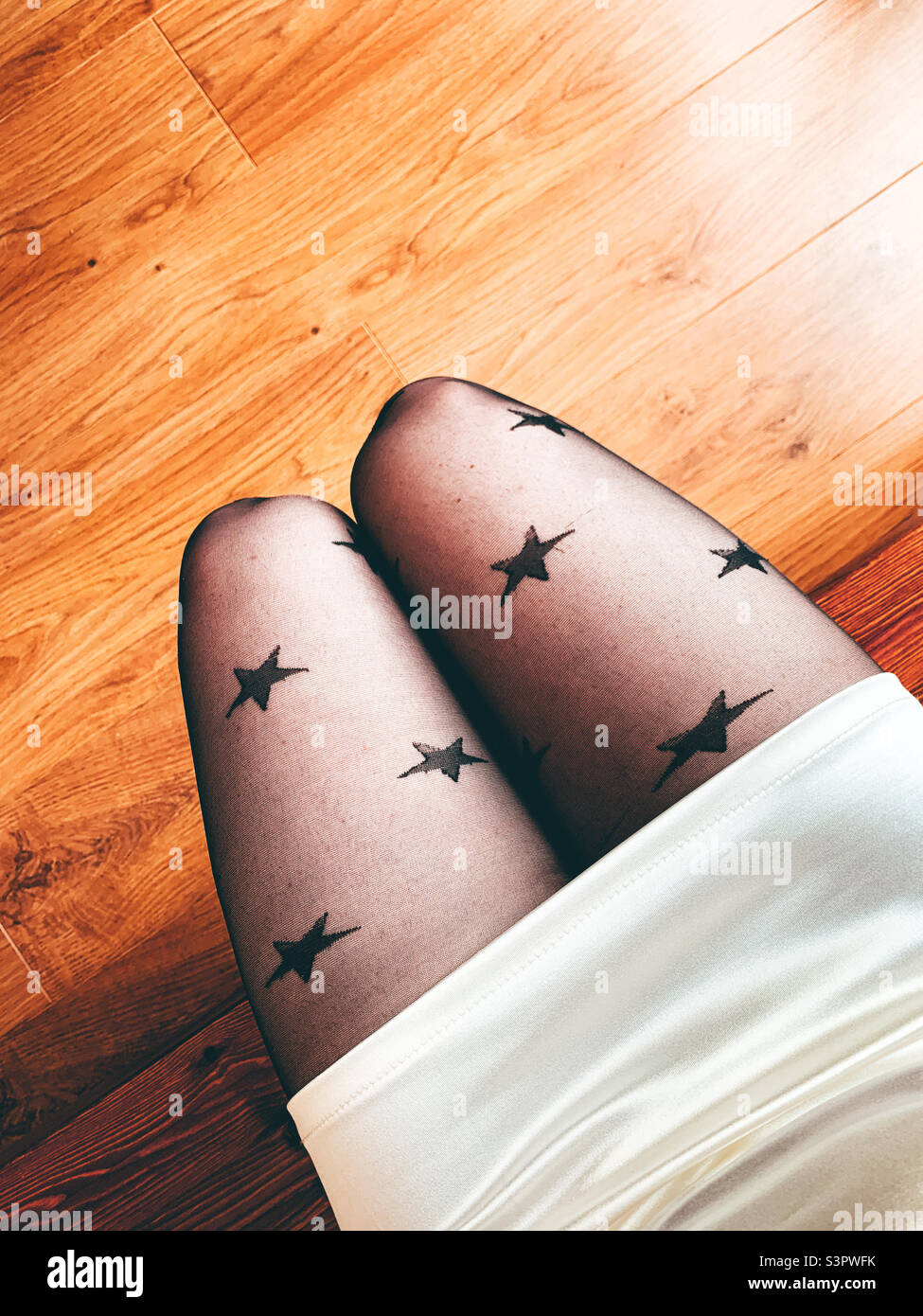 Woman sat down wearing star tights - Smartphone Captured Stock Image
