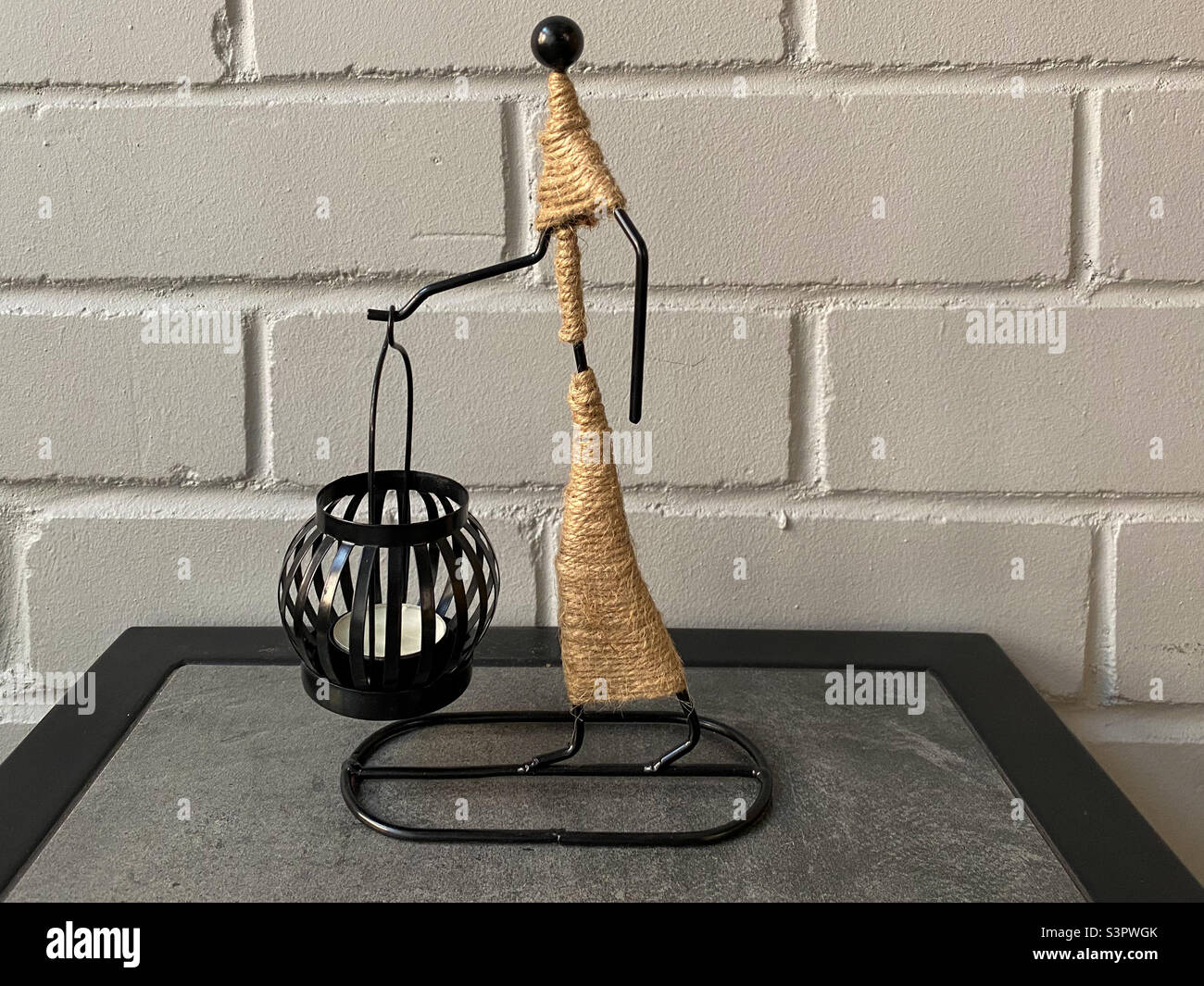 Decorative candle holder with a candle close-up. Statuette with a black candle holder - Smartphone Captured Stock Image