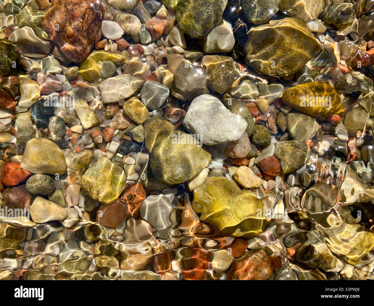 Background of colored river stones or pebbles under water. Top view. Clean and clear water - Smartphone Captured Stock Image