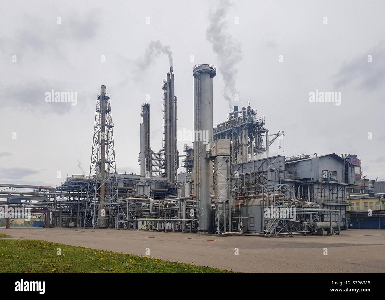 Large-capacity workshop for the production of ammonia of a petrochemical plant. The outer part of the tube furnace, shaft converter, CO2 absorber with copy space. Ammonia workshop under heavy polluted Stock Photo