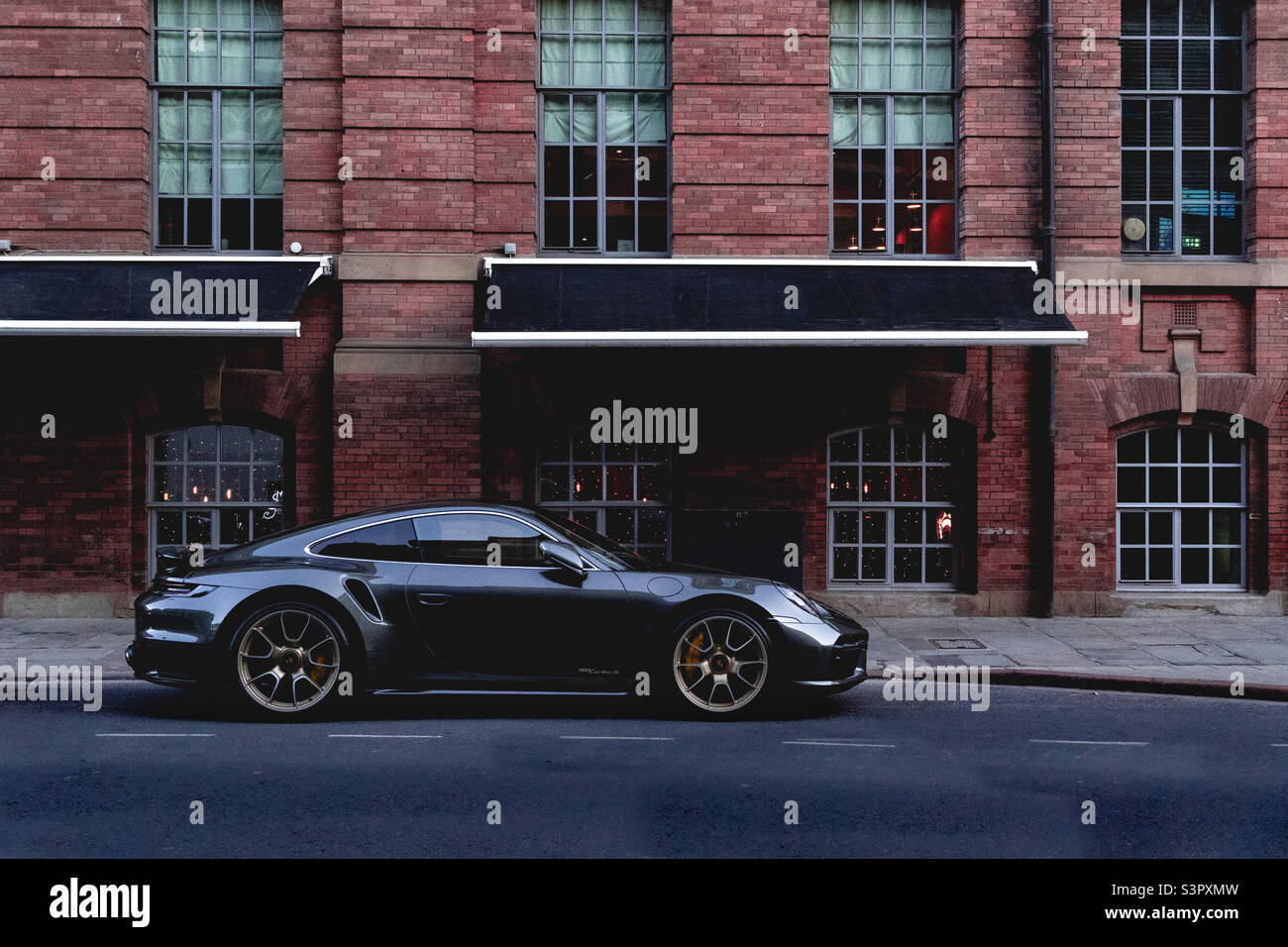 Expensive Porsche super car parked outside a luxury hotel building on a street in Leedsor London Stock Photo